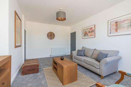 a living room with a couch and a coffee table at Spacious 3 bed flat- Free parking Edinburgh & Fife in Inverkeithing