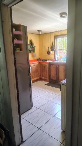 a kitchen with wooden cabinets and a refrigerator at Habitación cómoda, con estacionamiento in Temuco