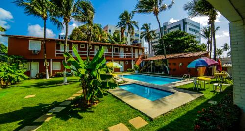 una imagen del patio de un hotel con piscina en Pousada das Araras, en Maceió