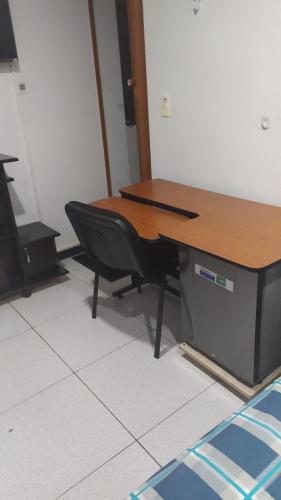 a desk with a chair sitting next to a table at Apartamento-Habitación Palonegro Manizales in Manizales