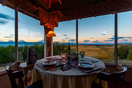 a table in a room with a large window at El Galpón del Glaciar in El Calafate