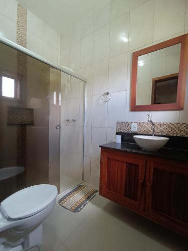 a bathroom with a toilet and a sink and a mirror at Sítio da Pedra in Cunha