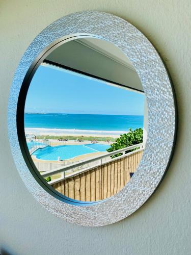 a mirror hanging on a wall with a view of the ocean at Excellence Suites Orient Beach Oceanview King-Size Beach Pool Parking in Cul de Sac