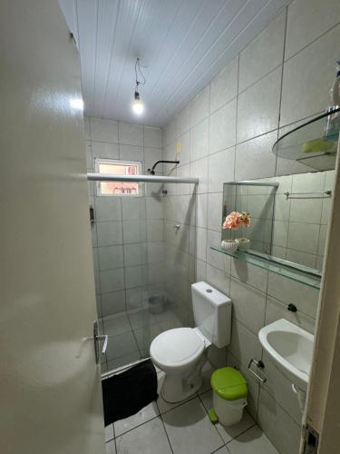 a white bathroom with a toilet and a sink at Casa do Sossego in Itamaracá