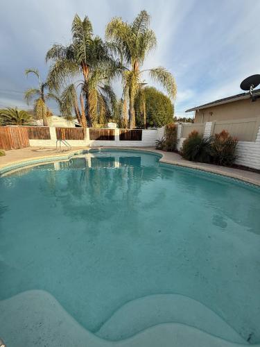 a large swimming pool in a yard with palm trees at Entire home, Heated Pool, Free Parking, WiFi, Pets are allowed in San Diego