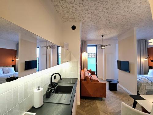 a bathroom with a sink and a living room at ROOSEVELTA RESIDENCE Apartments - przy OFF Piotrkowska in Łódź