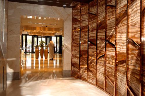 a lobby with a wall of wood logs at Braira Al Olaya in Riyadh