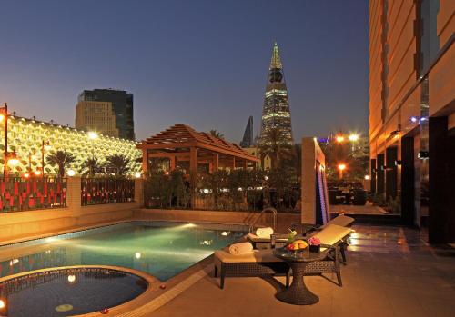 a swimming pool in the middle of a city at night at Braira Al Olaya in Riyadh