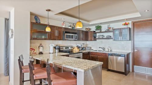 a kitchen with wooden cabinets and a large counter top at Encanto Living Two Bedroom Unit by Kivoya in Puerto Peñasco