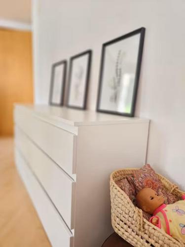 a white dresser with a doll in a basket at Perle am Vierwaldstättersee in Fluelen