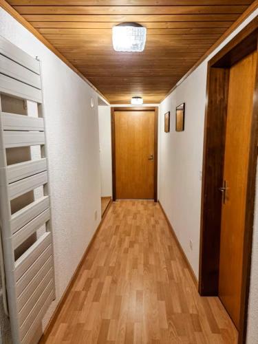 an empty hallway with a door and a wooden floor at Perle am Vierwaldstättersee in Fluelen