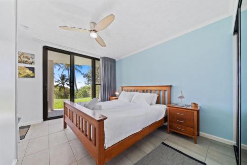 Un dormitorio con una cama y un ventilador de techo. en Mooloomba Four by Discover Stradbroke, en Point Lookout