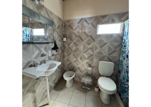 a bathroom with a sink and a toilet and a mirror at Complejo en camino de la costa in Gualeguaychú