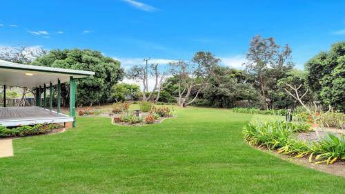 a garden with a bench in the grass at Birdsong in Wooli