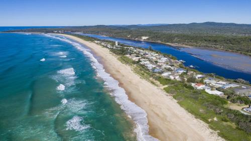 an aerial view of a beach and the ocean at Birdsong in Wooli