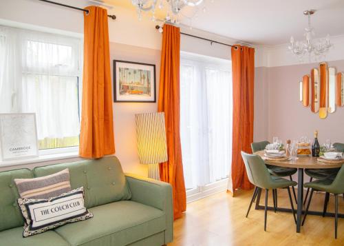 a living room with a green couch and a table at 3x Bed Elegant House with Private Parking in Sawston