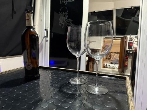two wine glasses sitting on a counter with a bottle of wine at Barco Puerto Calero in Puerto Calero