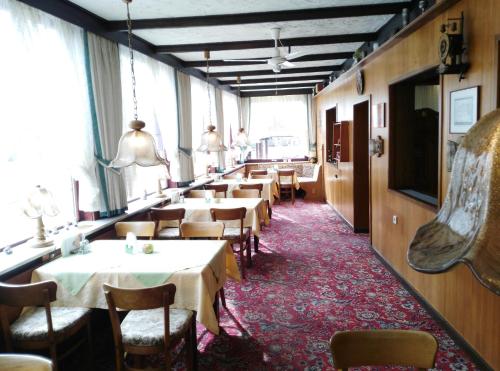 eine Reihe von Tischen und Stühlen in einem Restaurant in der Unterkunft Moocks Hotel in Altenau