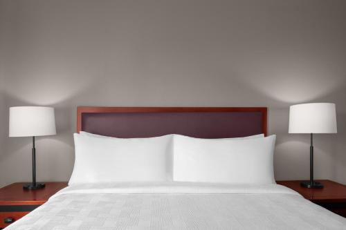 a bedroom with a bed with two lamps on tables at Larkspur Landing Extended Stay Suites Folsom in Folsom