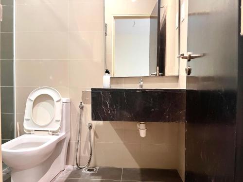 a bathroom with a toilet and a sink and a mirror at HillMark Suites in Ayer Keroh