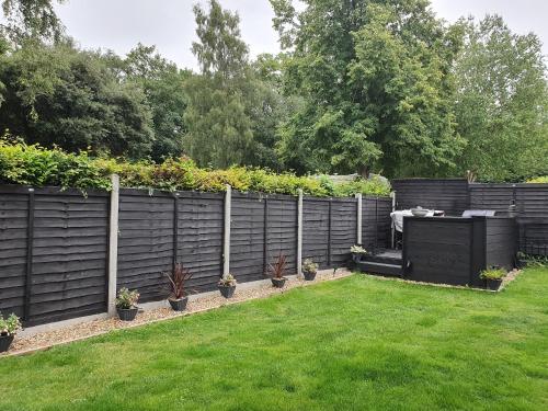 a garden with a fence with plants on it at College House in Crawley