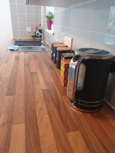 a kitchen with wooden floors and a counter top with a appliance at College House in Crawley