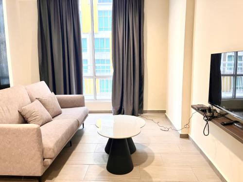 a living room with a couch and a tv at HillMark Suites in Ayer Keroh