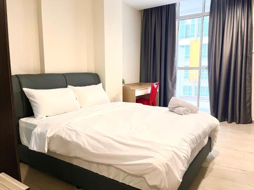 a bed in a room with a large window at HillLand Suites in Ayer Keroh