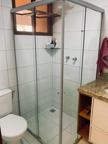 a bathroom with a glass shower with a toilet at Chalé Sertão e Mar in Canguaretama