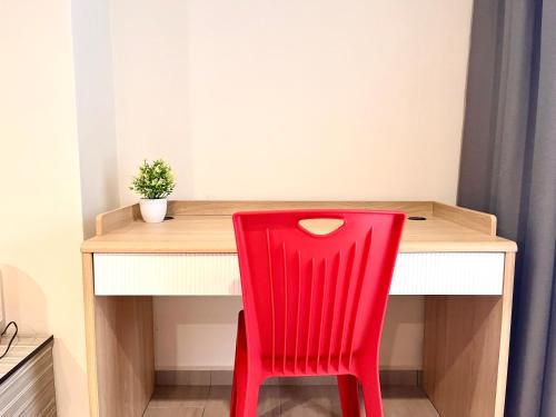 a red chair sitting in front of a wooden desk at HillLand Suites in Ayer Keroh