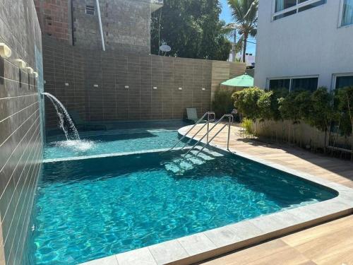 einen Pool mit einem Brunnen im Hof in der Unterkunft Apartamento em Porto de Galinhas in Porto De Galinhas