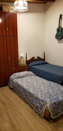 a bedroom with a bed and a guitar on the wall at Cómodo monoambiente en macrocentro de Rosario in Rosario