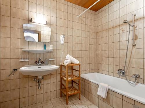 a bathroom with a sink and a tub and a shower at Appartements Zellner in Alpbach