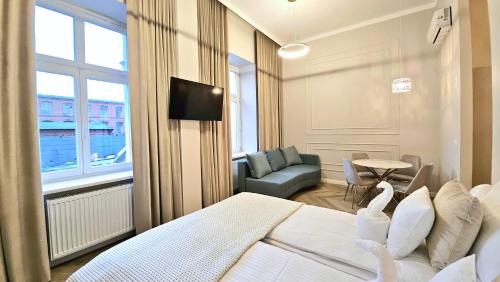 a bedroom with a bed and a tv and a couch at ROOSEVELTA RESIDENCE Apartments - przy OFF Piotrkowska in Łódź
