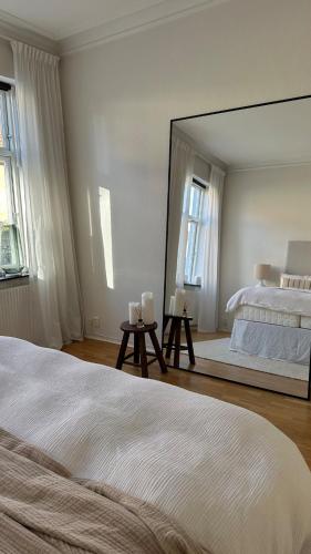 ein Schlafzimmer mit einem Bett und einem großen Spiegel in der Unterkunft Tågaborg in Helsingborg
