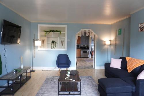 a living room with a blue couch and a table at Central Aptniagrafallwifibillkitchenwdking in Buffalo