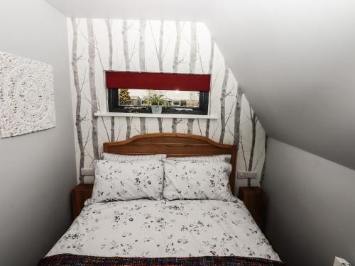 a small bedroom with a bed with a window at Silver Birch Lodge in Bawtry