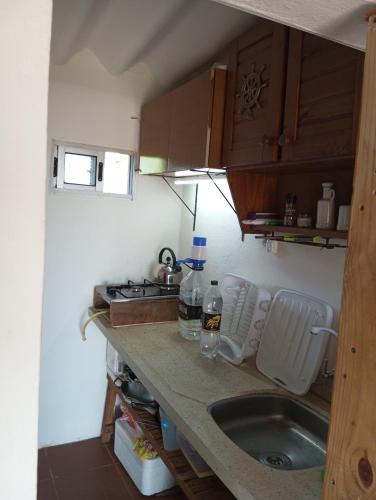 a small kitchen with a sink and a stove at El Navegante in Cabo Polonio