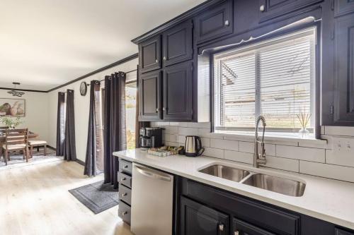 a kitchen with dark blue cabinets and a sink at Cozy 3 Bedroom House Near DFW in Bedford
