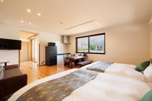 a hotel room with two beds and a dining room at Hakuba Highland Hotel in Hakuba