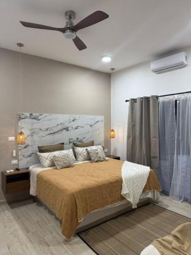 a bedroom with a bed with a ceiling fan at aldea isla sagrada in Cozumel