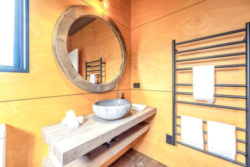 un bagno con lavandino e specchio di Villa Obsidian including Obsidian Yurts by Waiheke Pure a Waiheke Island