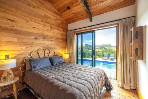 una camera da letto con un letto e una grande finestra di Villa Obsidian including Obsidian Yurts by Waiheke Pure a Waiheke Island