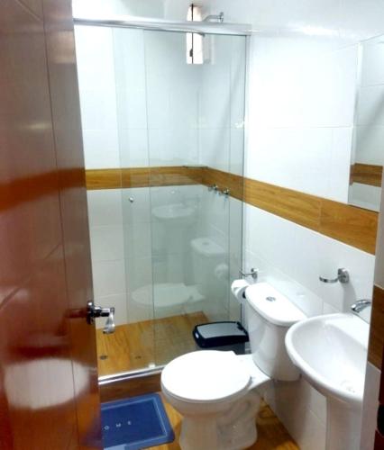 a bathroom with a shower and a toilet and a sink at Retama Lodging in Cusco