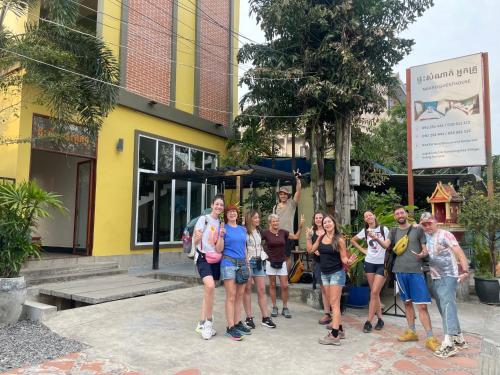 a group of people standing in front of a building at Neakru Guesthouse and Restaurant in Kampot