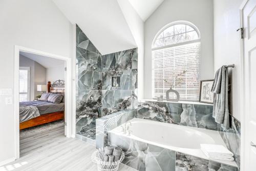 a bathroom with a tub and a bedroom with a bed at 9 Mi to The Domain Spacious Pflugerville Haven! in Pflugerville