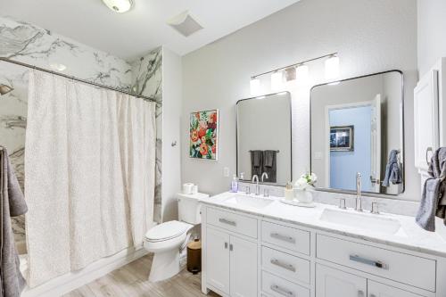 a white bathroom with a sink and a toilet at 9 Mi to The Domain Spacious Pflugerville Haven! in Pflugerville