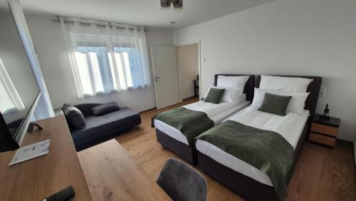 a hotel room with two beds and a couch at Apartments Seibel Doppel-Zweibettzimmer mit Küche und Wintergarten in Reutlingen