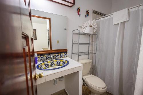 a bathroom with a sink and a toilet and a mirror at Las Mariposas Hotel & Studios in Oaxaca City