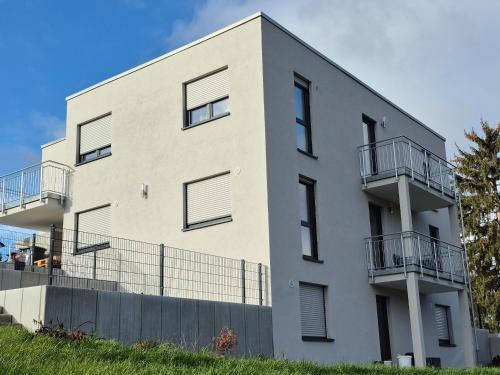a white building with balconies on it at Apartments Seibel Doppel-Zweibettzimmer mit Küche und Wintergarten in Reutlingen